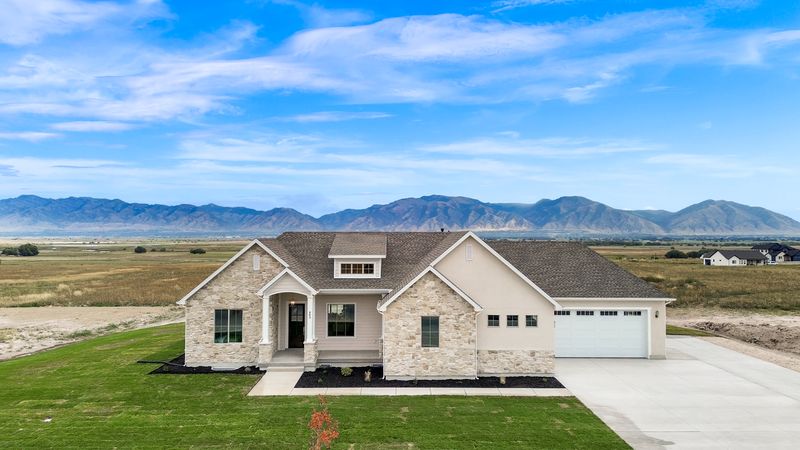 Aerial view of the home with the Wellsville Mountains and Cache Valley behind