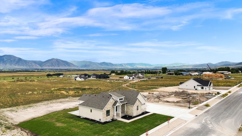 Aerial view of the home on its lot with the street and the valley beyond