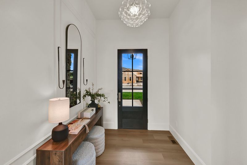 Entry hall with an 11-foot ceiling, a glass front door and a console table