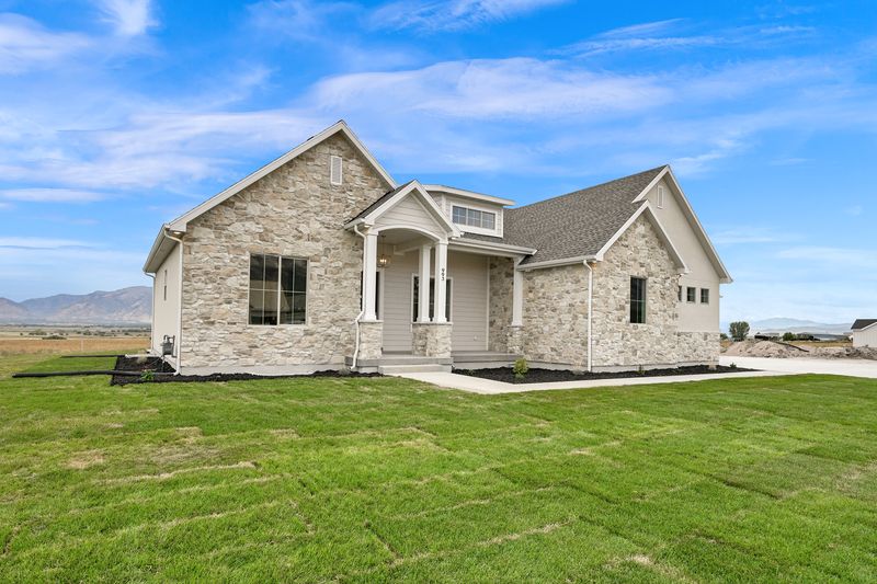The Sterling as built in Mendon, Utah: stone and stucco elevation with gabled rooflines and a covered entry