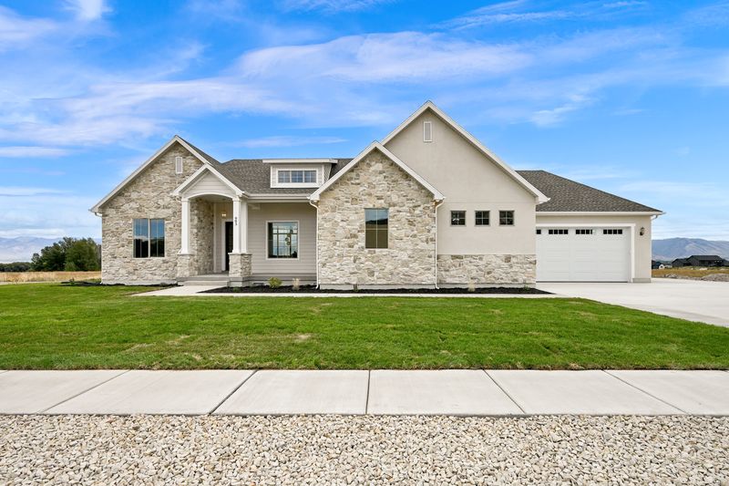Wide view of the full front elevation, stone on the left wing and stucco on the right