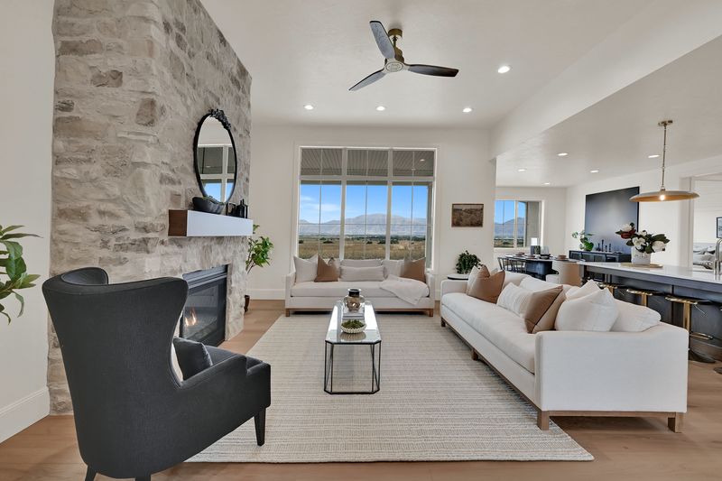 View past the stone fireplace across the seating area toward the kitchen