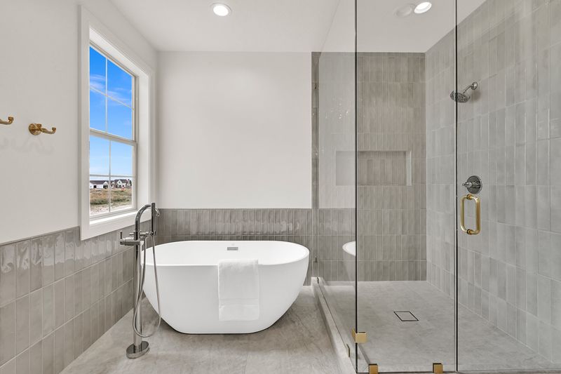 Primary bath from the vanity side, tub and walk-in shower along the tiled wall