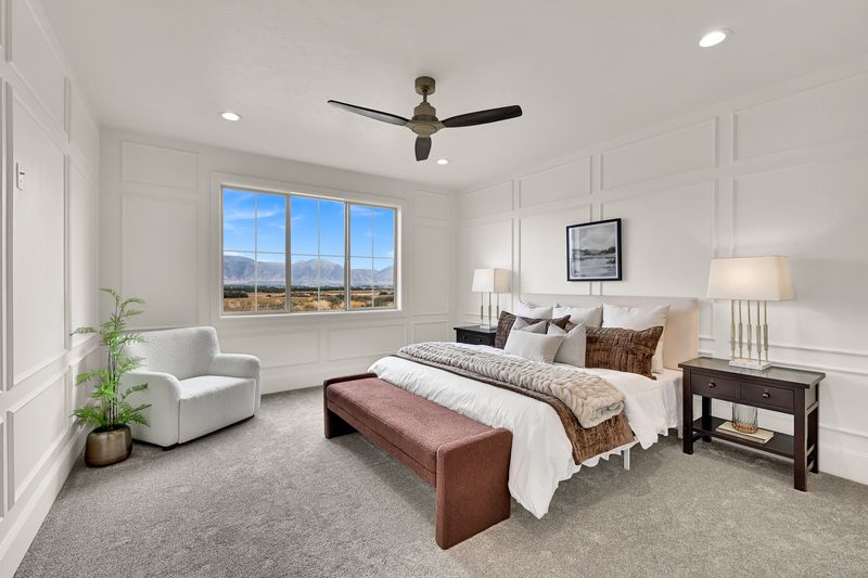 Primary bedroom with panelled walls, a ceiling fan and a window onto the mountains